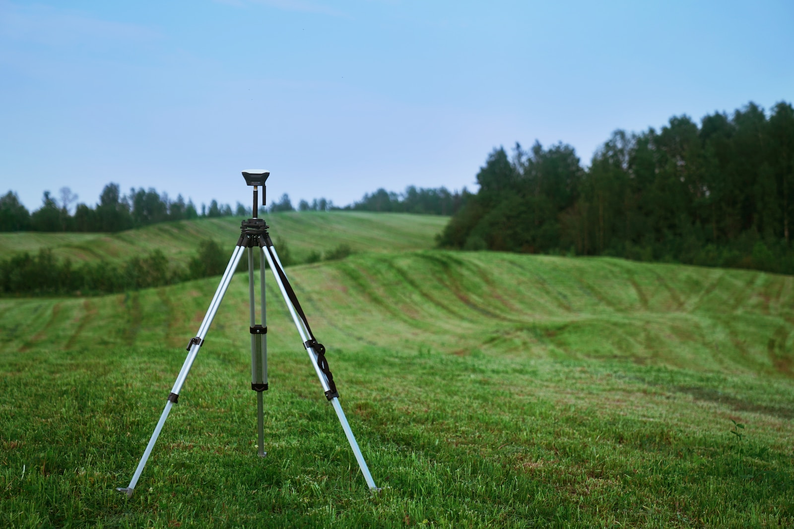 black and white tripod on green grass field during daytime